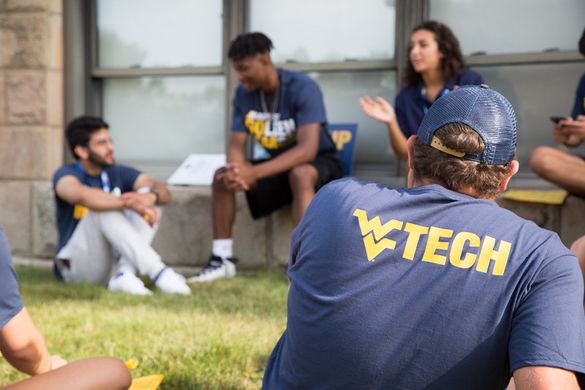 Students in branded WVU Tech shirts chat outside